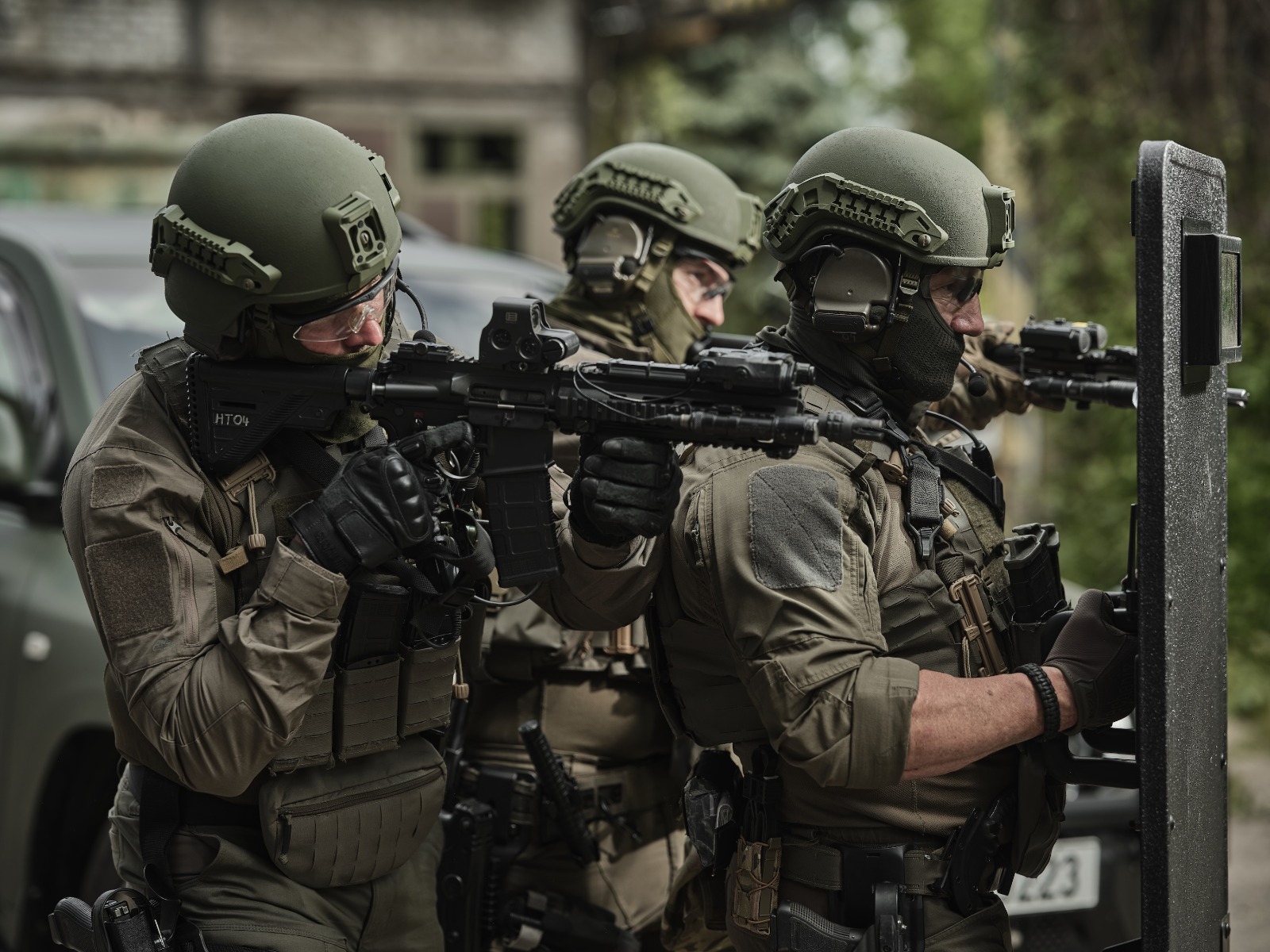Operators wearing CES ballistic helmets and body armour with a ballistic shield